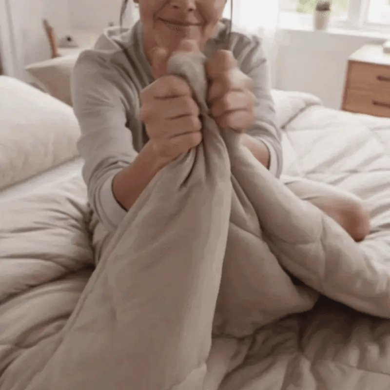 Une femme secoue la couette Peasy Sleep pour refaire son lit en quelques secondes